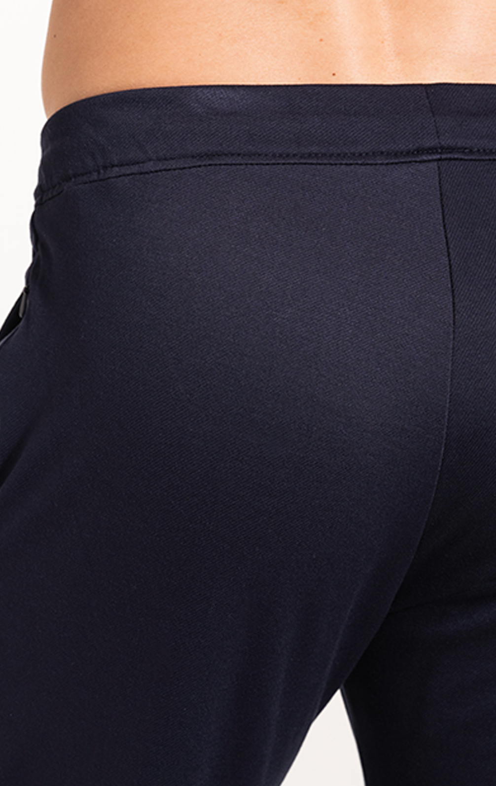 Close-up of a person’s lower back and upper legs wearing Twillory Athlounger Jogger in dark navy. The waistband, side seam, and comfort fabric stand out against a plain white background, showcasing the jogger's fit and texture.