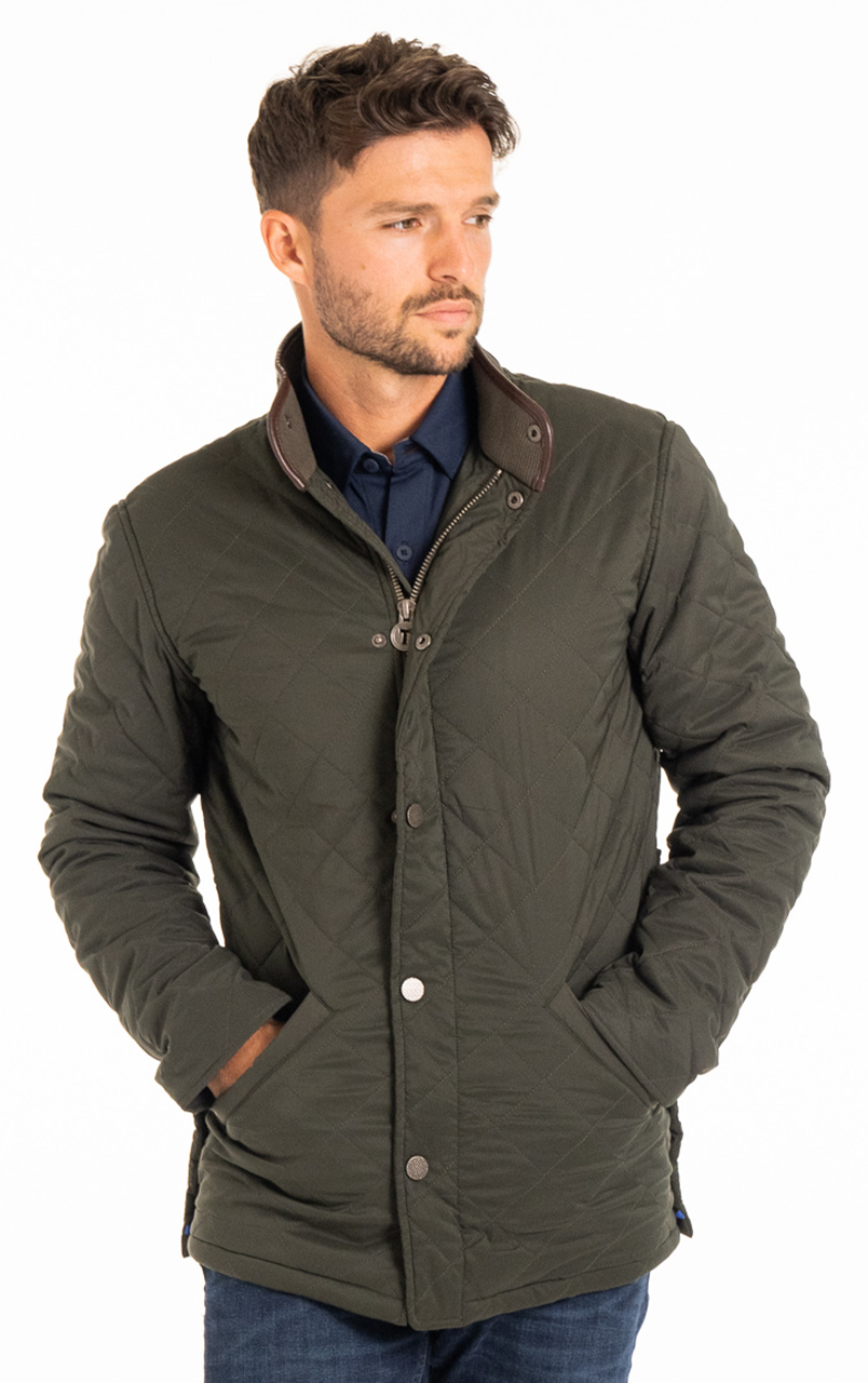 Man wearing a stylish quilted green jacket with snap button closure and standing against a white background.