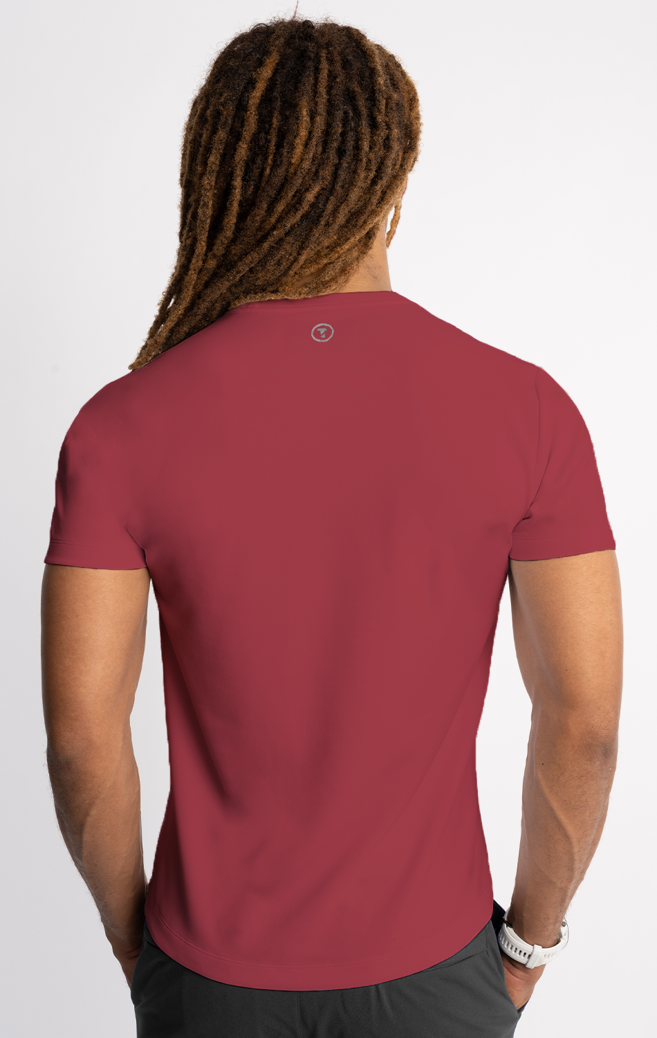Man with dreadlocks wearing a red T-shirt viewed from the back.
